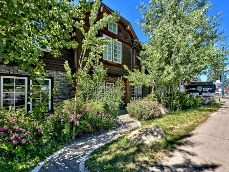 A charming building surrounded by greenery, with a sign reading 