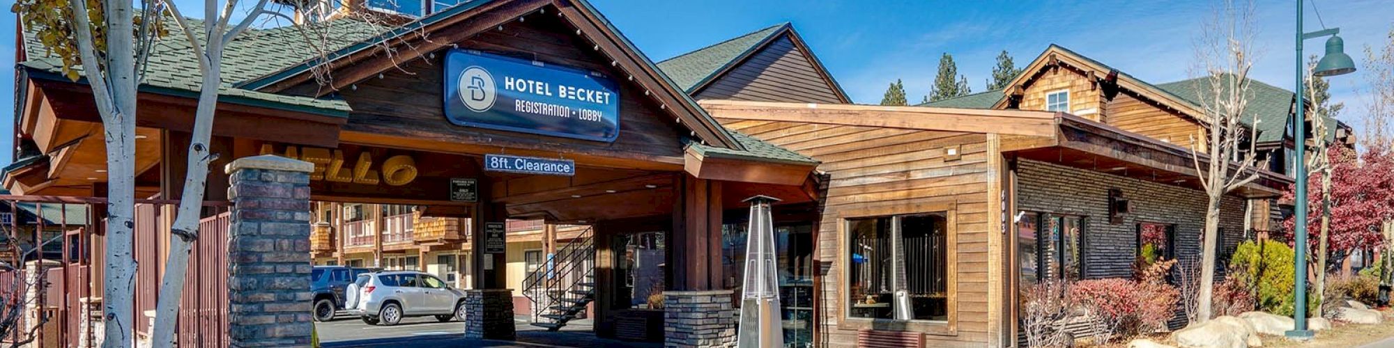 An exterior view of a rustic hotel entrance with a sign reading 